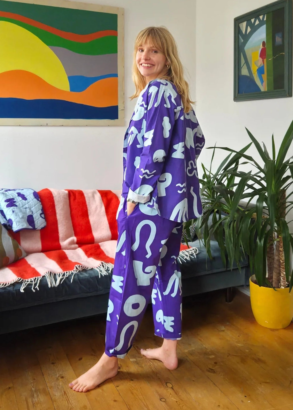 Person wearing a blue outfit with white patterns in a living room.