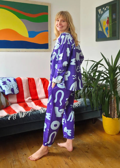 Person wearing a blue outfit with white patterns in a living room.